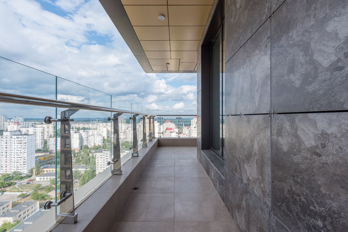 Guarda-corpo de vidro em sacada, com torres de inox e corrimão tubular